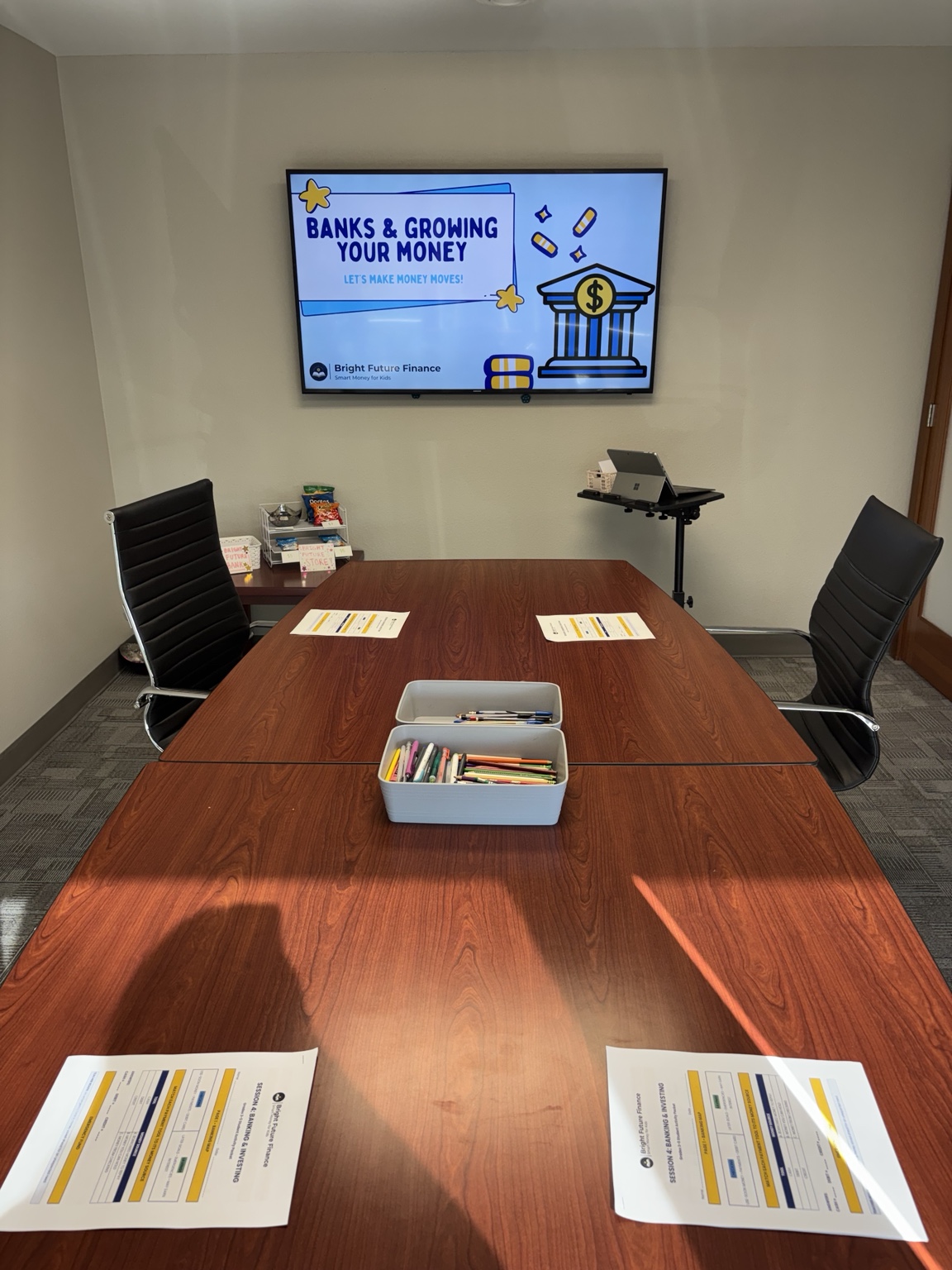 Classroom prepared for a banking lesson with a presentation, worksheets, and pencils